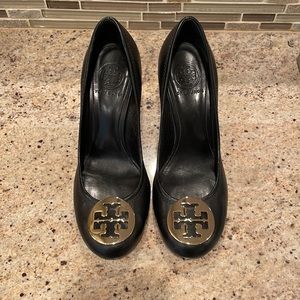 Tory Burch size 8 black wedge heels with gold metal emblem.